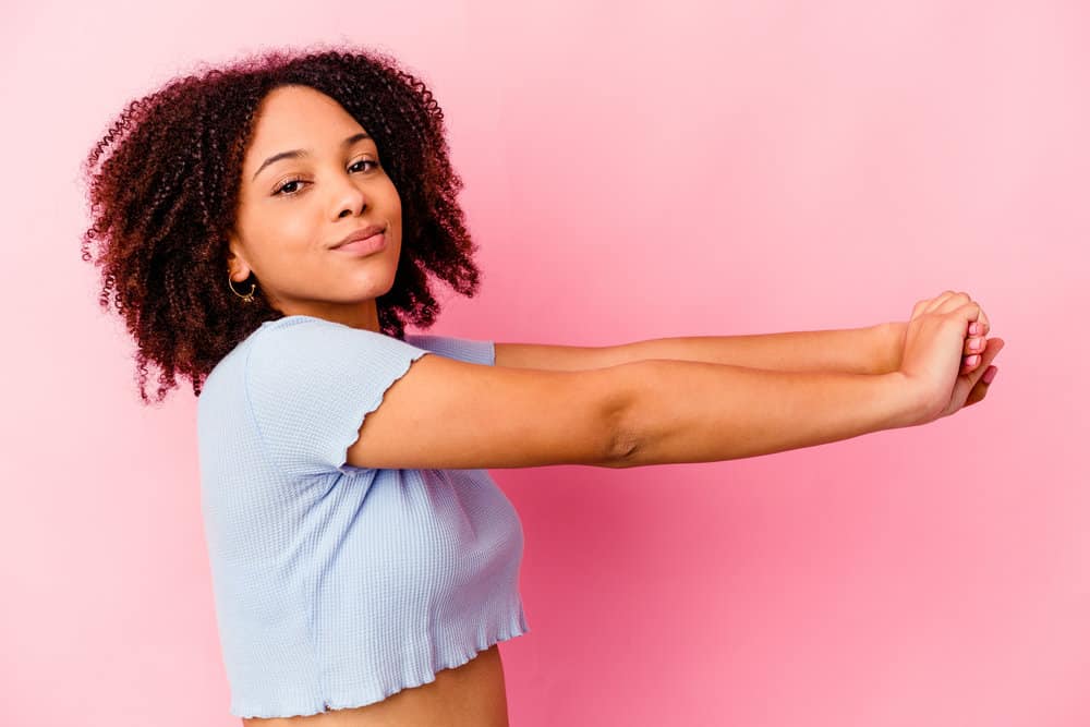 A cute young African female with a coily texture wearing bouncy curls after taking down her bantu knots.