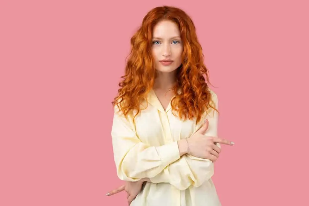 What Is 2A Hair? How To Take Care of It, Styles, and Products 3 An elegant redhead female with wavy locks that has been treated with the Curly Girl hair care routine.