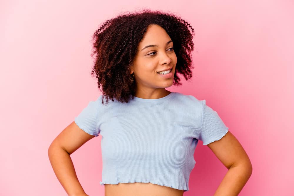 A lady with one of the most common curly hair types for black girls - tightly wound 4A small curls styled with castor oil.