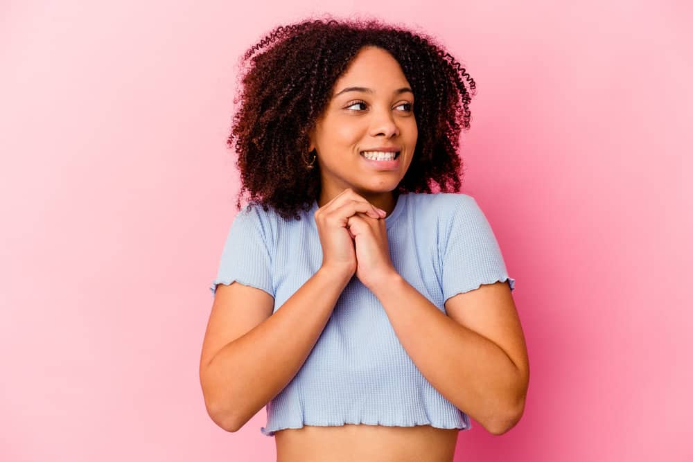 A beautiful female wearing a cotton t-shirt wanting to limit hair shaft and cuticle damage with hot tools.