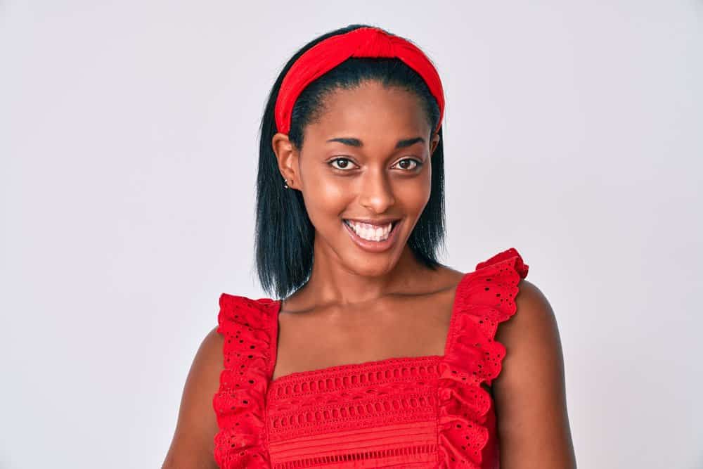 A cute young black woman with frizzy hair after getting a keratin treatment and letting her hair air dry.