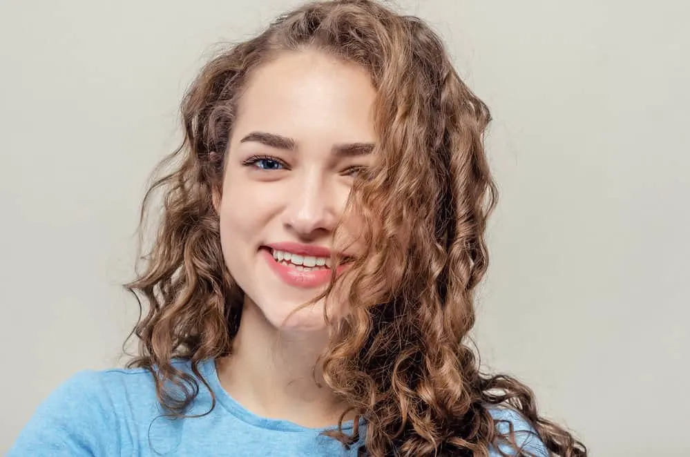 What Type of Curly Hair Do I Have? A Detailed Curl Type Guide 3 A beautiful young female with a wavy hair type wearing loose curls styled with styling cream.