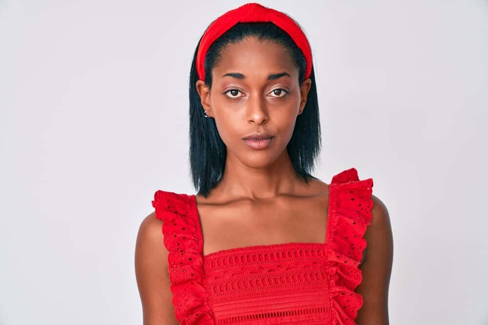 Young black female after leaving the hair salon getting a hair repair treatment and blow drying hair with a heated dryer.