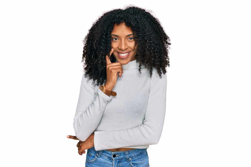 A young African American woman with brittle hair as a result of too much protein and heat-related hair problems.