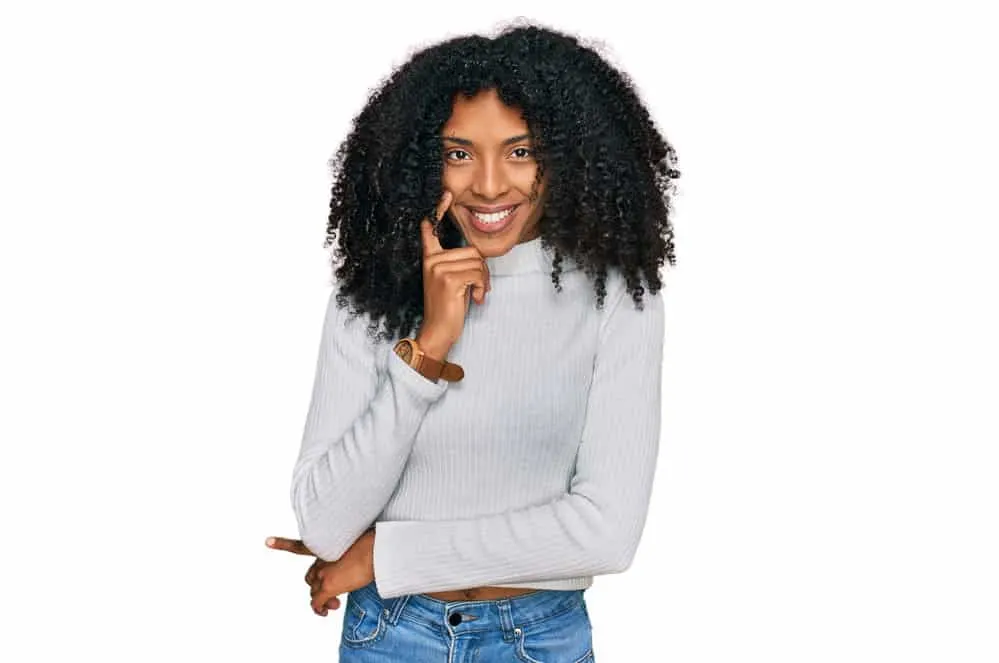 Why Is My Hair Stretchy? Is It Normal? What Does It Mean? 10 A young African American woman with brittle hair as a result of too much protein and heat-related hair problems.