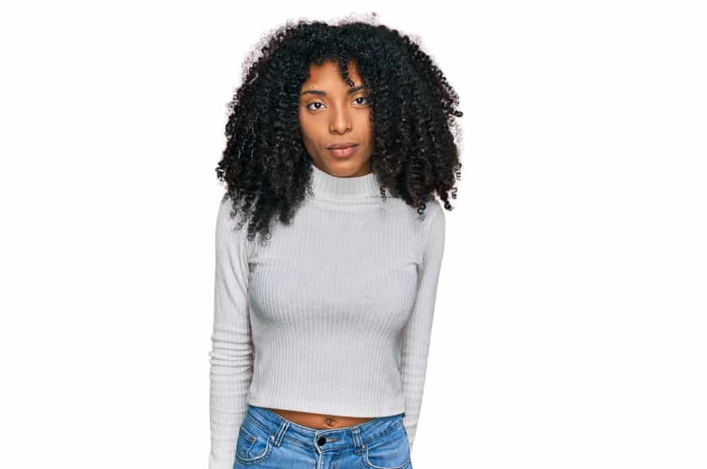 A young African American female with dry hair due to her hair's elasticity issues from using chemical treatments.