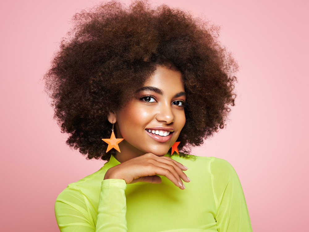 Beautiful black woman wearing one of the latest hair trends - an Alicia Keys-inspired afro with extra volume.