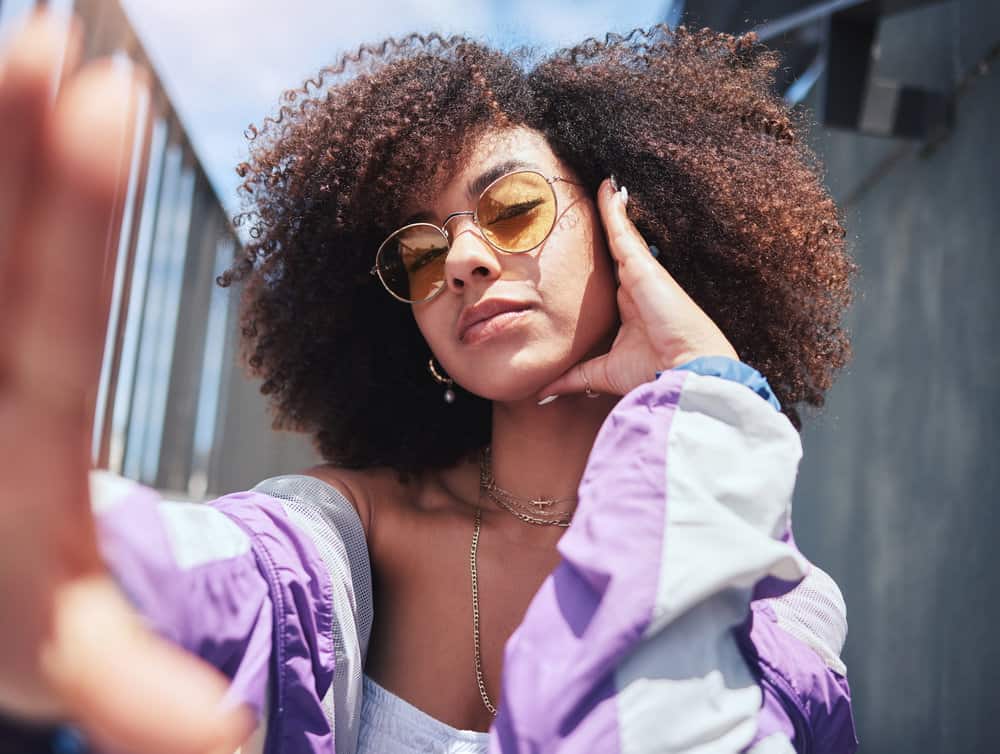 A pretty young lady during a photoshoot with her curls styled with shea oil, avocado oil, and other essential oils.