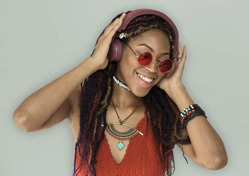 Buckshot Hair Meaning Explained: How to Fix Curly Buckshots 5 A black lady listening to the "Ole Buck Shot" podcast on her Beats headphones while wearing a braided hairstyle.