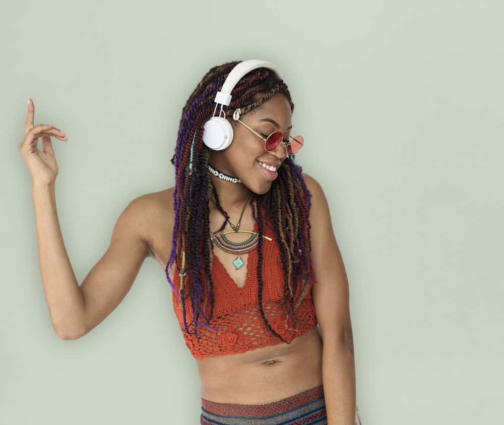 A black woman wearing braids is listening to music from a new African American rapper named "Little Knapps".