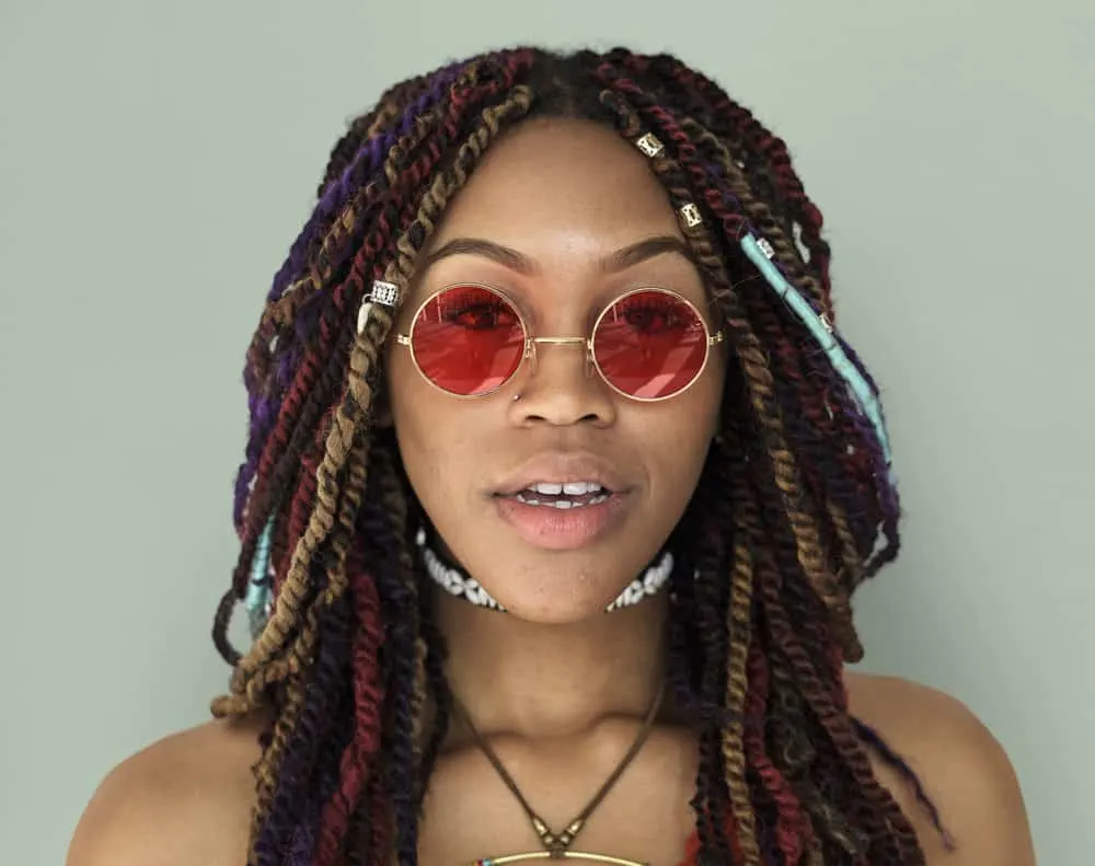Buckshot Hair Meaning Explained: How to Fix Curly Buckshots 7 A lady with multi-colored synthetic braids has buck shots in the kitchen area of her hair along the nape of her neck.