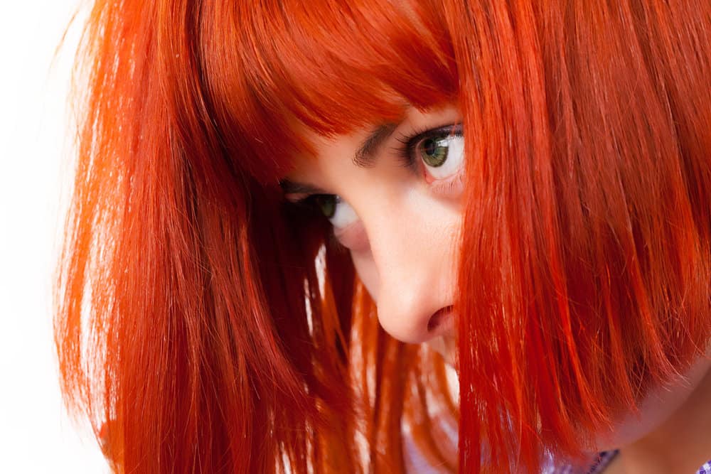 Caucasian female with her bleached hair covered in a vivid color Splat dye that creates a unique appearance.