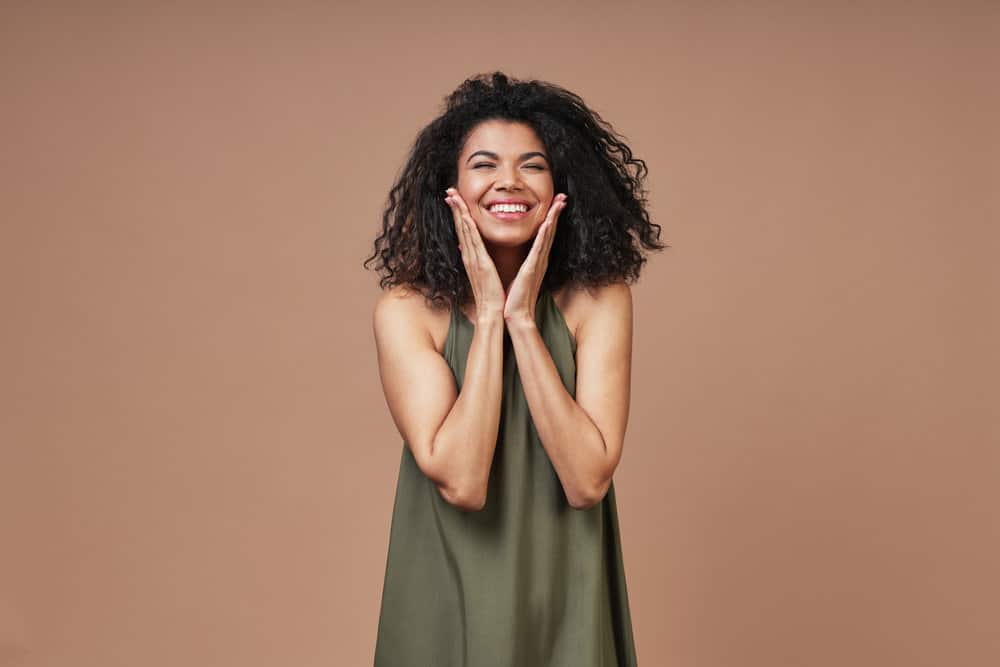 A black female with dark brown natural hair that's starting her curly hair journey with a bentonite clay hair treatment.