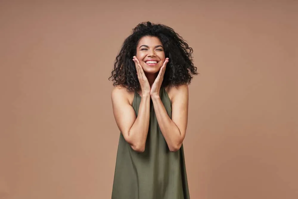 How to Get Curly Hair Back After Straightening It Too Much 6 A black female with dark brown natural hair that's starting her curly hair journey with a bentonite clay hair treatment.