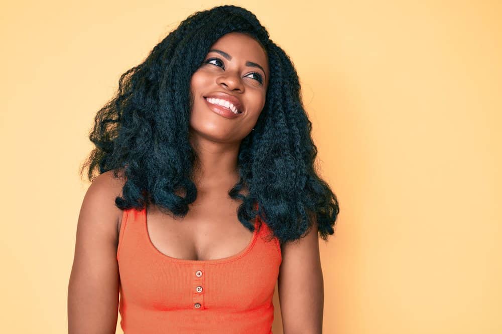 A cute young lady dried her wet hair with heating tools and styled her curls with wig-specific products.