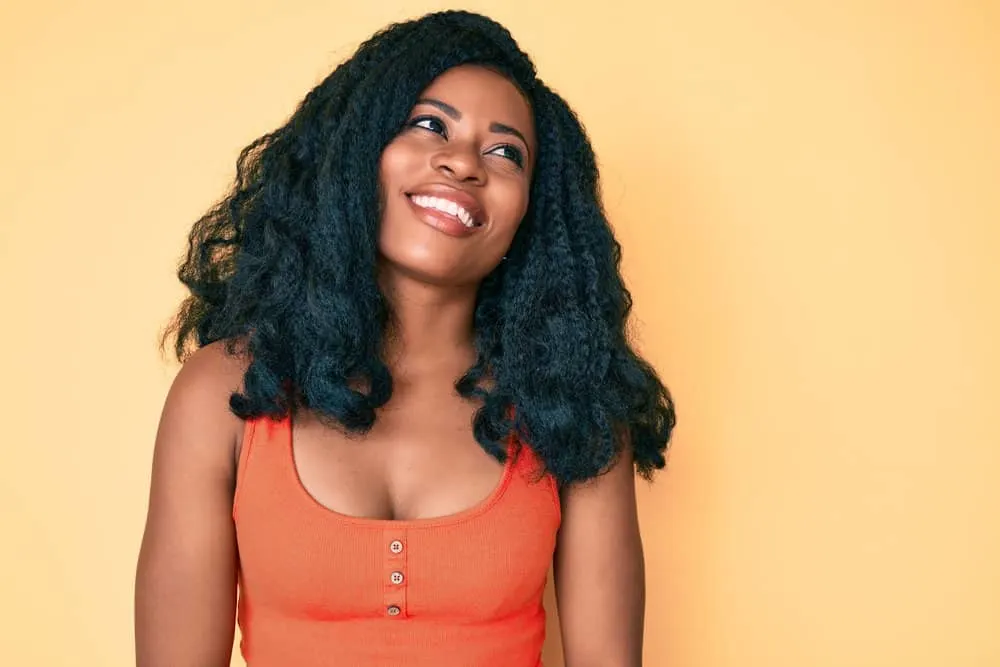 Can You Put Mousse on Synthetic Hair? Synthetic Wigs, Weaves & Braids? 4 A cute young lady dried her wet hair with heating tools and styled her curls with wig-specific products.