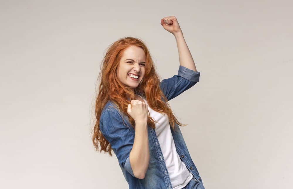 A nice young female with a defined wave pattern wearing a denim blue-jean jacket and a white t-shirt.