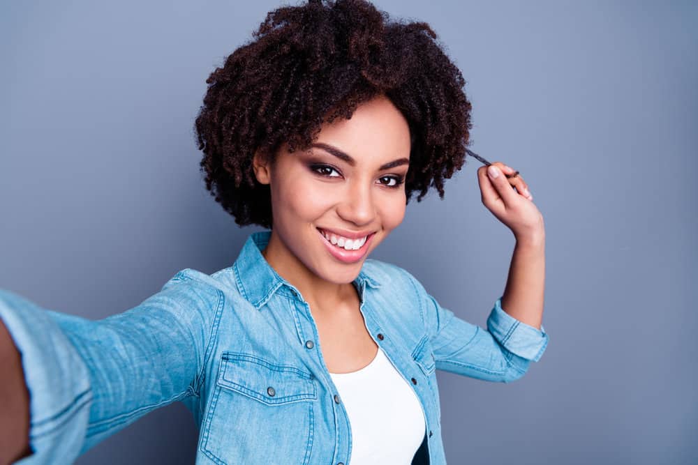 Cute black girl with dry hair after getting a hot oil treatment with olive oil by her hair stylist on her 4C hair type.