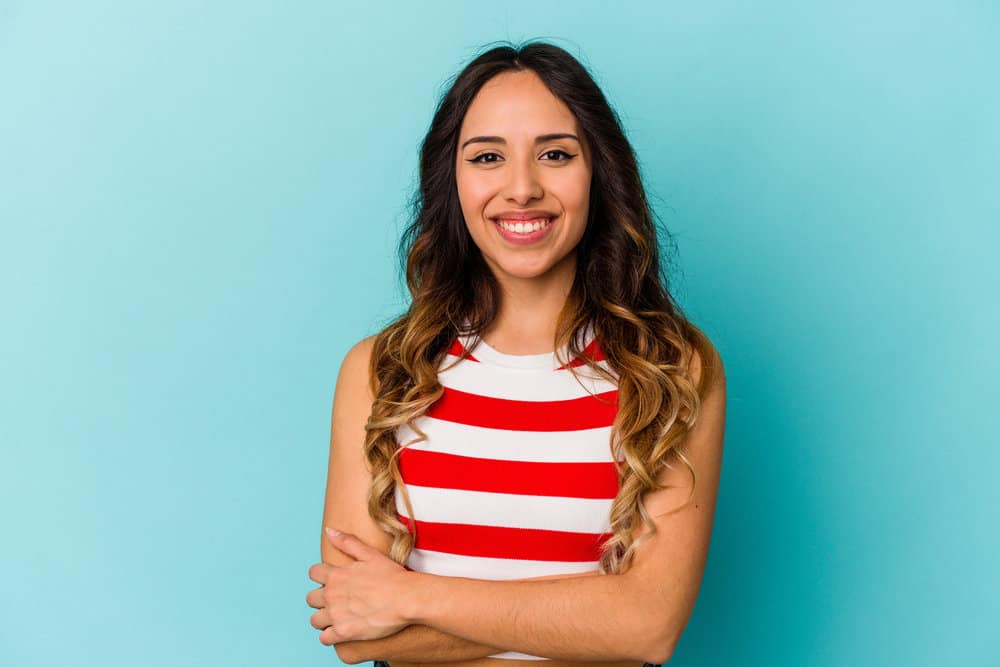 A cute young Mexican lady with semi-permanent hair dye on her dark brown ombre-colored hair follicles.