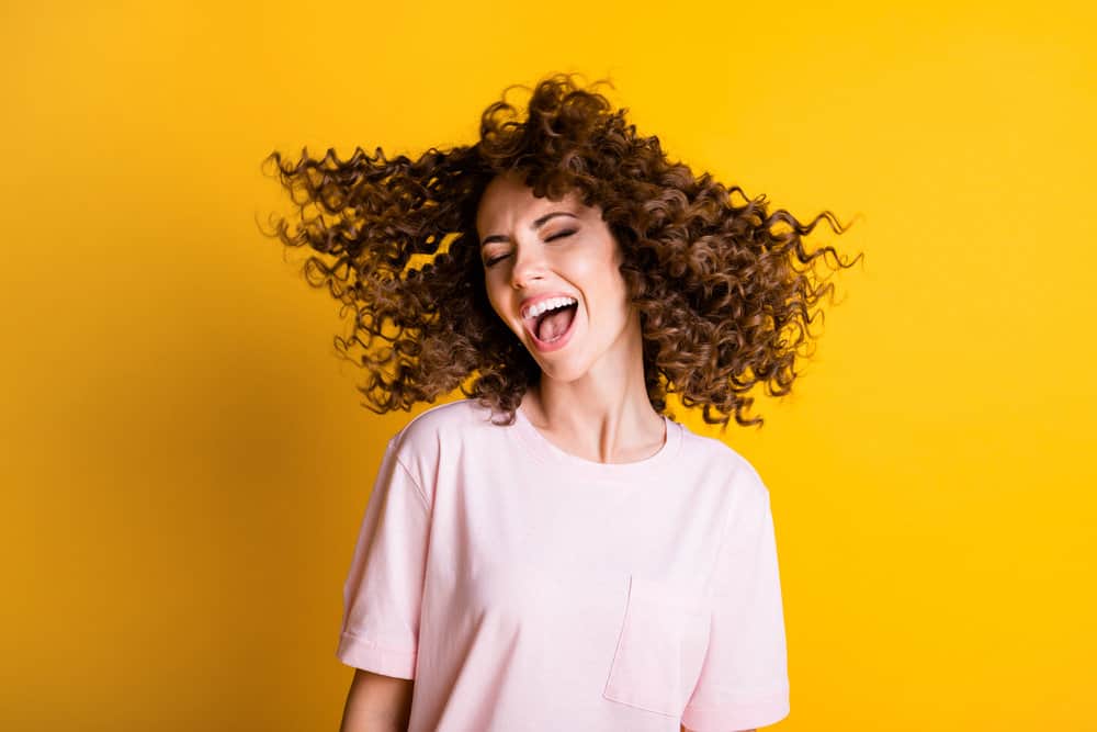 A lady that's laughing after learning how to create beautiful straight hairstyles following straightening her curls.