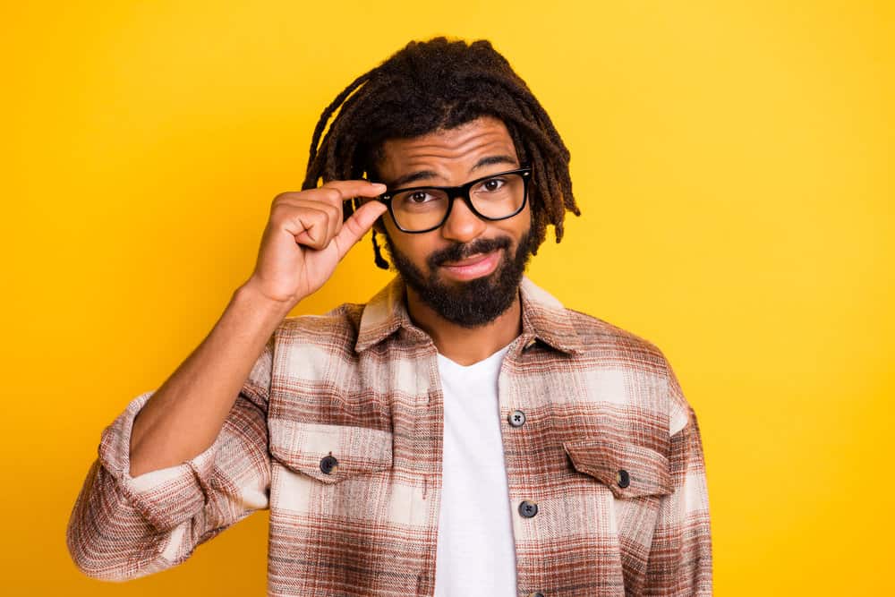 A young African American man with free-form locks with bleached tips wearing a style like many rappers.