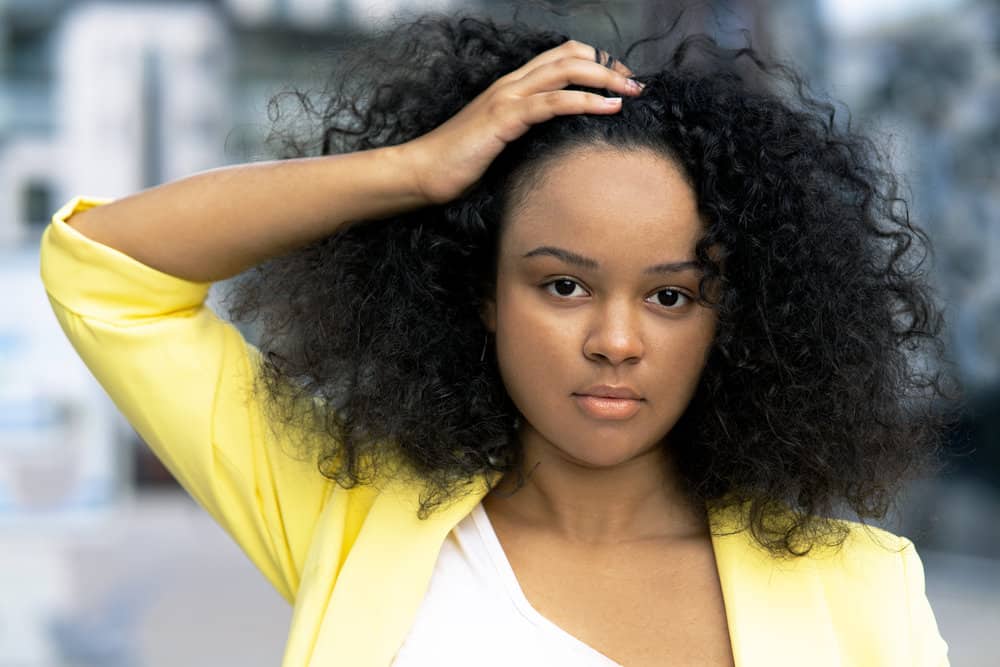 Attractive lady with shiny hair post keratin treatment enjoying her formaldehyde-free natural curls.