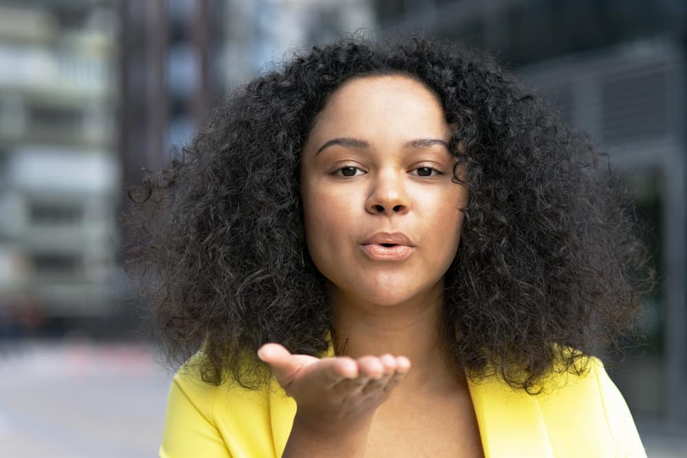 A beautiful young black female with naturally curly hair after getting a keratin-based treatment. 
