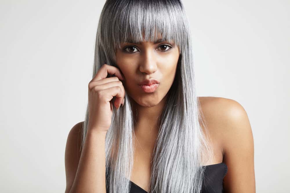 A cute black girl leaving a professional hair colorist has a fully gray natural color as she undergoes gray blending. 