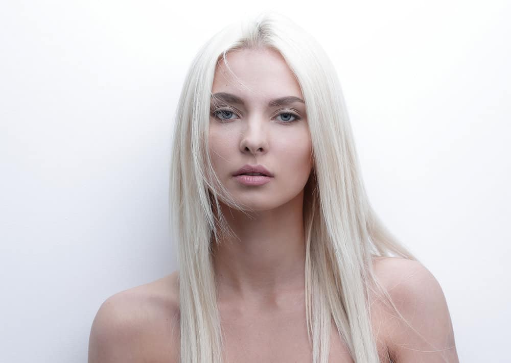 An amazing young woman with light blonde permanent hair color with a serious look.