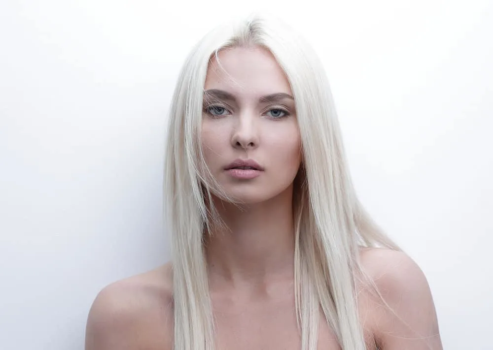 An amazing young woman with light blonde permanent hair color with a serious look.