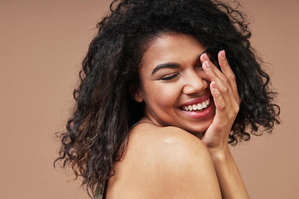 A young black lady with hair damage from straightening hair with a flat iron with too much heat.