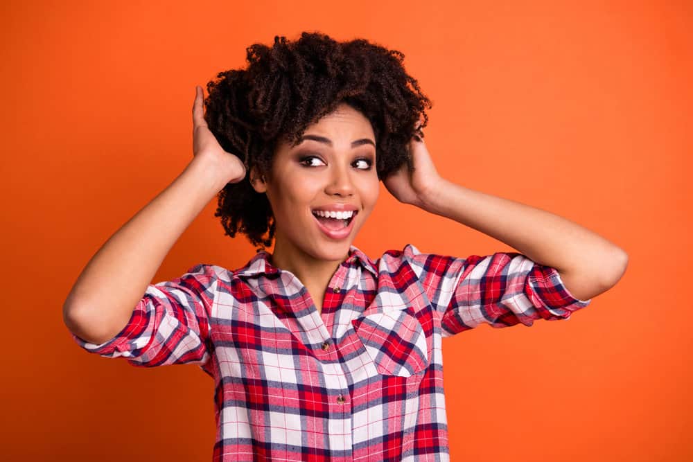 A young African American woman with shorter hair styled with organic styling products for curly hair types.