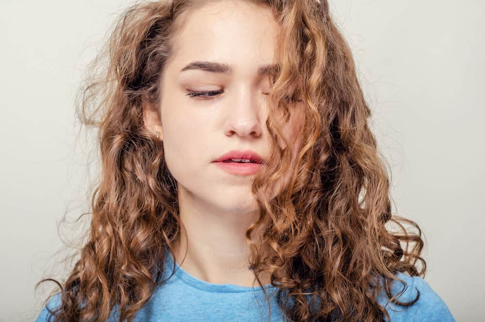 A white lady with a beachy wave pattern has a combination of 2C and 3A hair strands on one head.