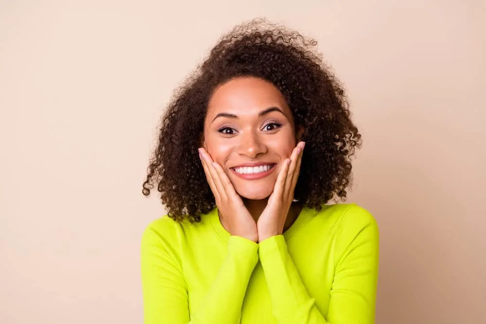 Is Love Beauty and Planet Good for Hair Care? Hair Growth? 12 A pretty young black lady with curly hair feeling amazing after leaving the hair salon for a wash 'n go style.