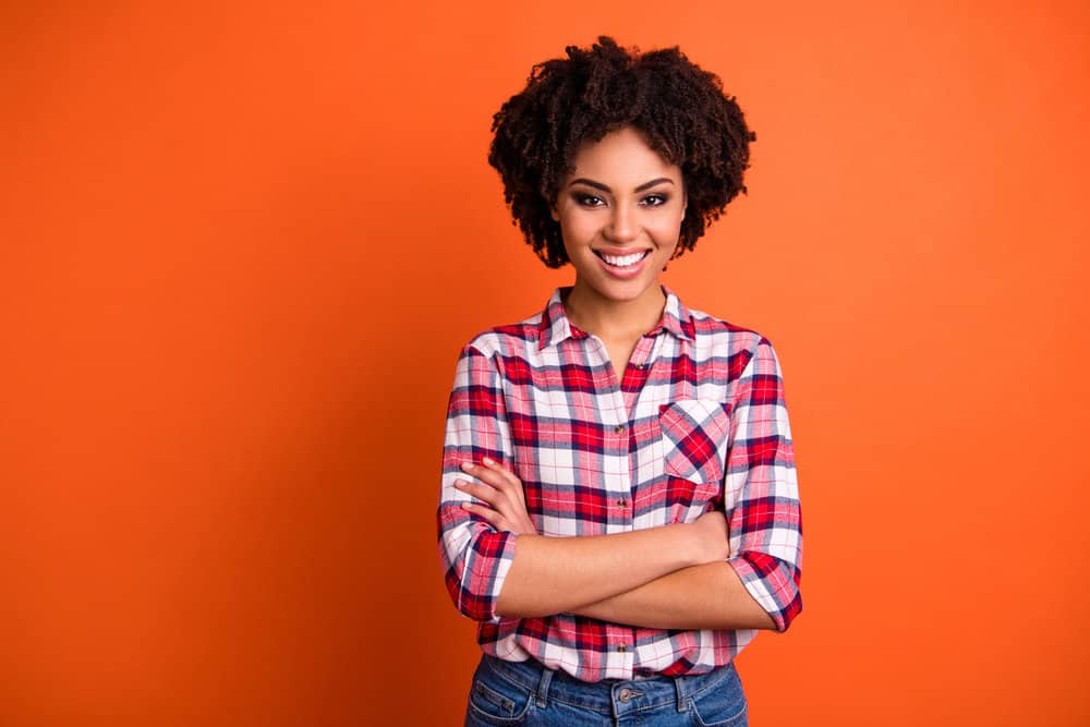 A black girl with frizz-free hair that doesn't lay down like straight hair due to type 4 strands with a curly hair follicle.