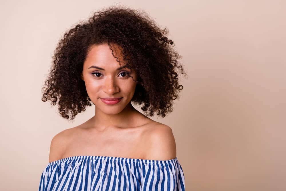 An adorable female with medium-brown curls styled with brown dye pigments and weekly conditioning treatments.