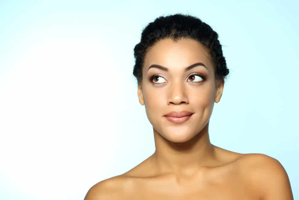 Cute young female poses after using a clarifying shampoo and olive oil to remove knots and make her hair tangle-free.