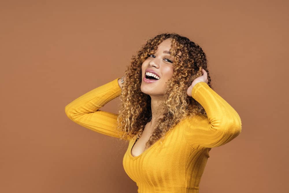 African American female with unevenly bleached hair showing very dark hair and light brown hair tones.