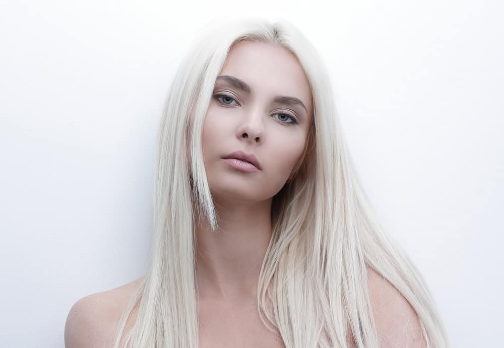 A beautiful female with light platinum blonde bleached hair with purple pigments after leaving the hair salon.