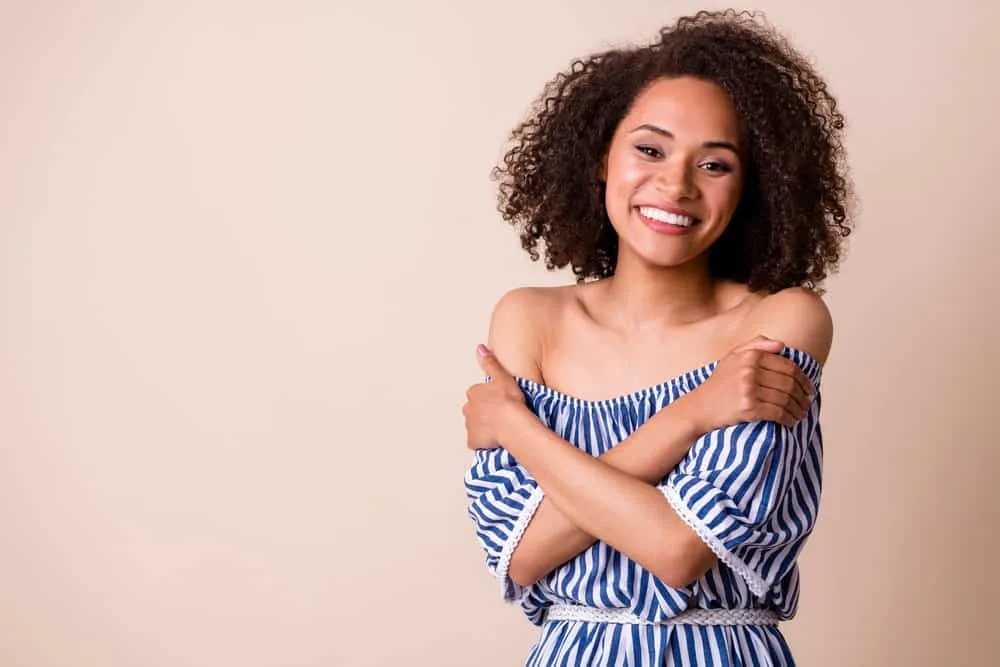 What Developer to Use to Darken Hair and Why? 10, 20, 30? 5 Light skinned black girl embracing herself with dark hair after using a no lift hair color in her natural curls.