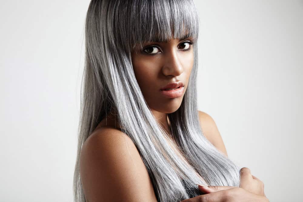 African American female that's a natural beauty is going gray naturally as her roots grow much lighter.