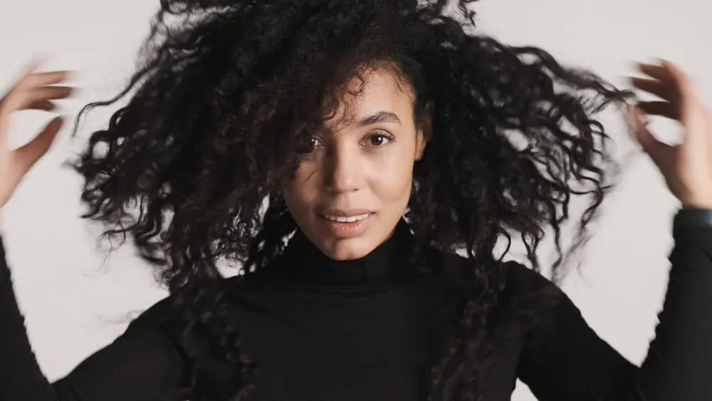 How to Thin Out Hair With and Without Thinning Shears 6 A woman used a blow dryer on her hair to add texture after using conditioning her curls with hair masks.