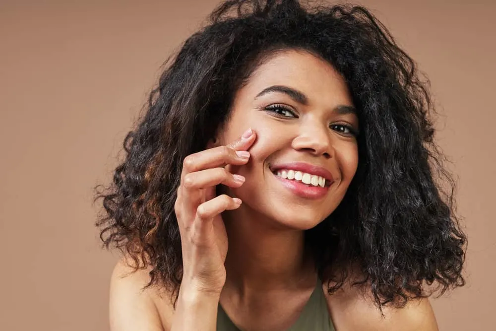How to Get Curly Hair Back After Straightening It Too Much 7 A beautiful black girl with healthy hair after wearing her hair straight following a traditional keratin treatment.