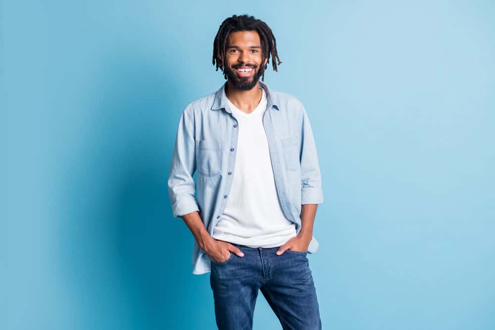 Satisfied dark-skinned male leaving Chick-fil-a with damp hair without wearing any loud jewelry.