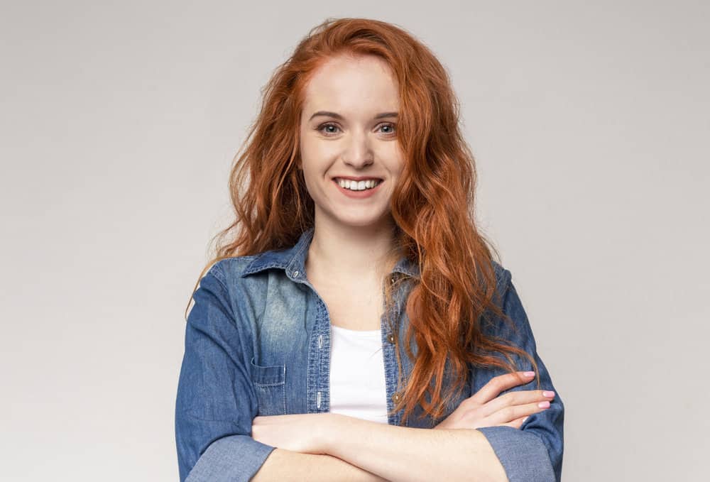 Cute redhead woman with textured hair that often styled curl creams, gels, and Curly Girl approved hair products.