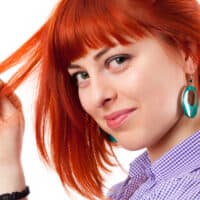 A female with red Splat dye over medium brown darker hair creates a vibrant color with semi-permanent hair color.