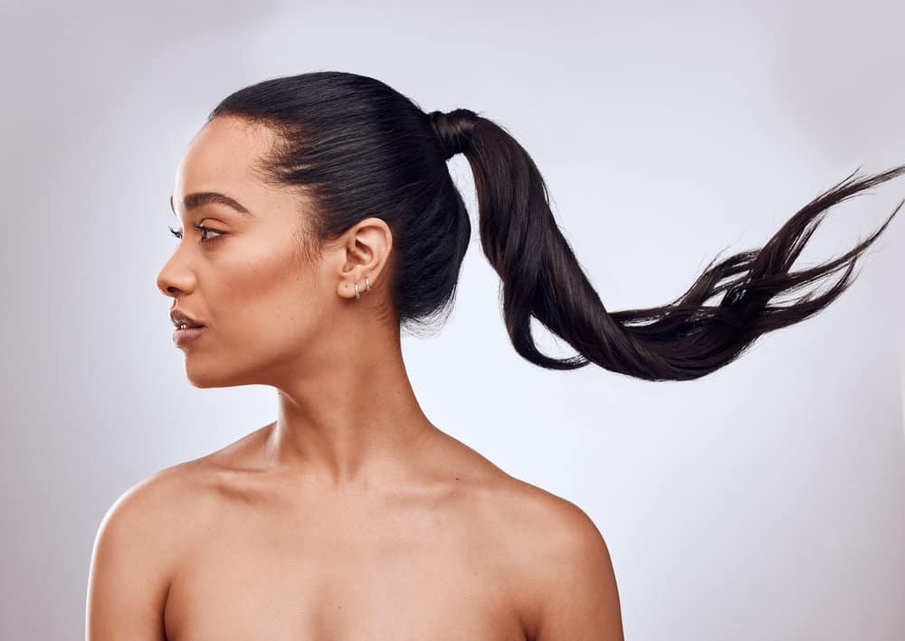 A lady after drying her wet hair completely with a blow dryer after using a sodium chloride treatment.