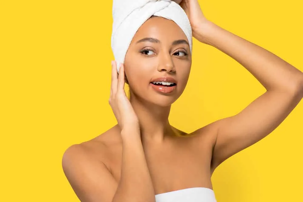 How to Plop Hair Overnight With a T-Shirt or Microfiber-Towel 9 A female with tighter curls removed the excess water from her wet curls before plopping it on an old t-shirt.