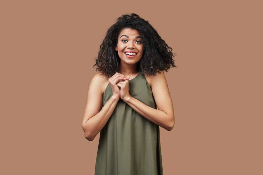 Beautiful young African woman's natural curls returned after getting a hair straightening treatment.