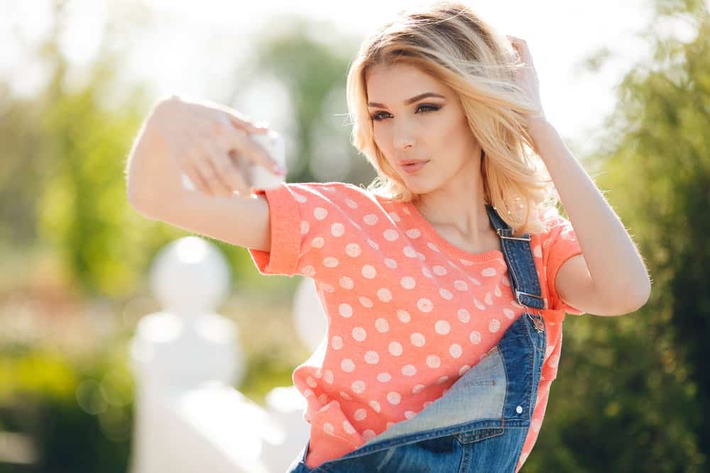 A young white girl with platinum blonde bleached hair done at home instead of using a professional hair stylist.